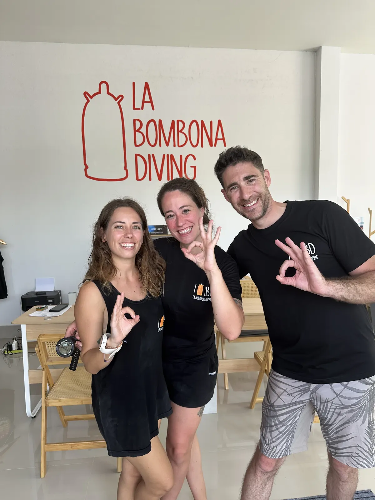 Buceadores recién certificados haciendo la señal de OK en La Bombona Diving
