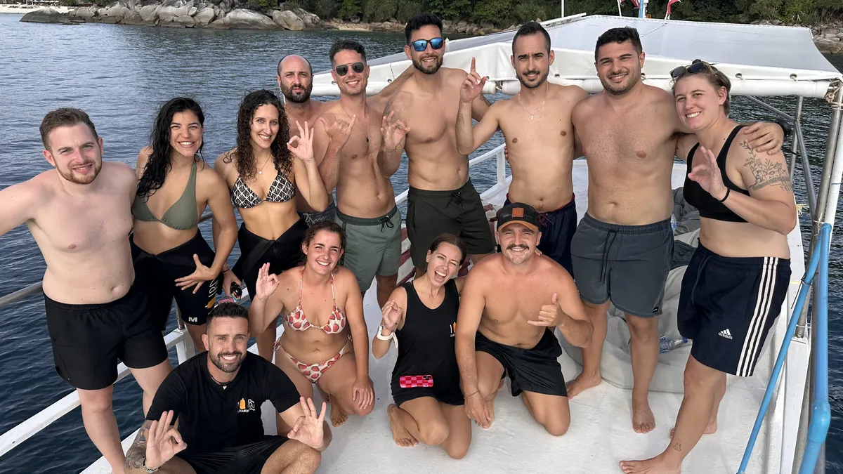 Buceadores avanzados recién certificados celebrándolo en el barco