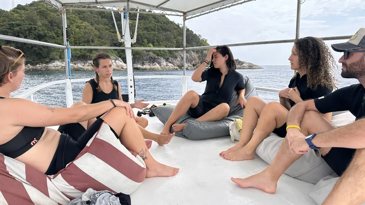 Alumnos del curso avanzado repasando la teoría en la cubierta del barco