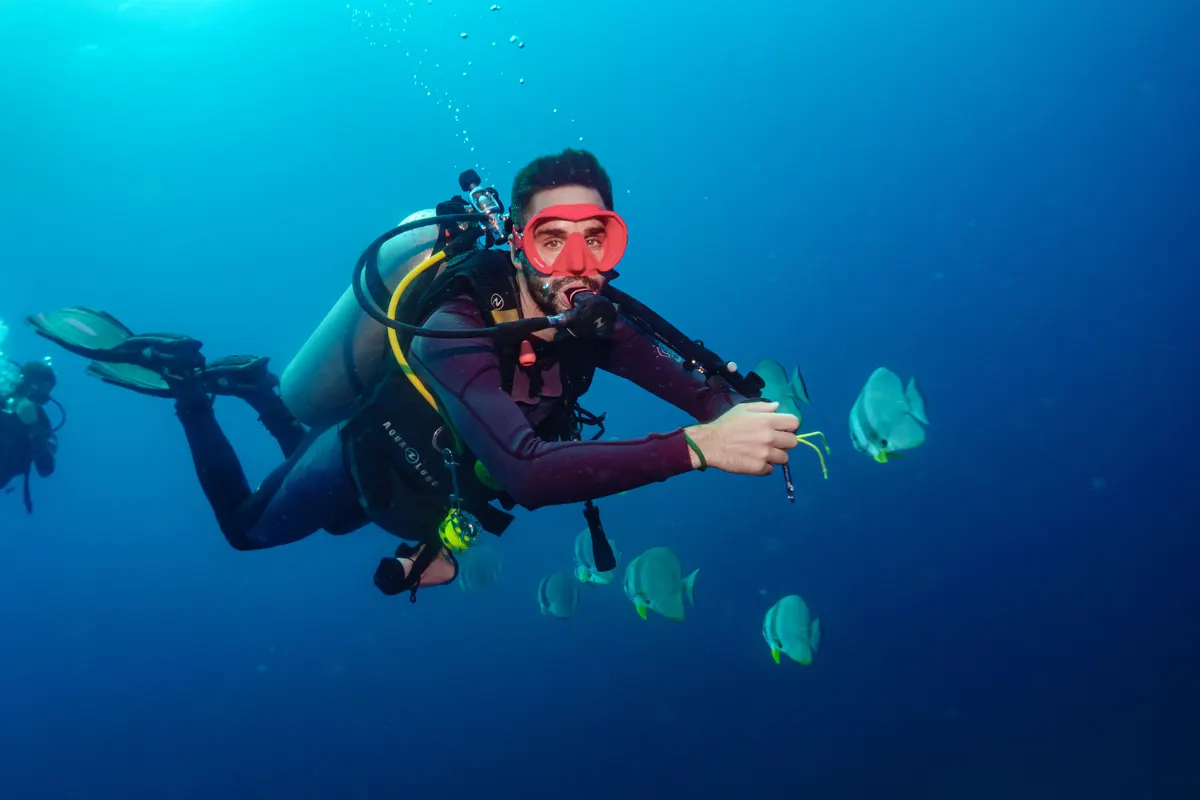 Buceador realizando un patrón de búsqueda en aguas azules